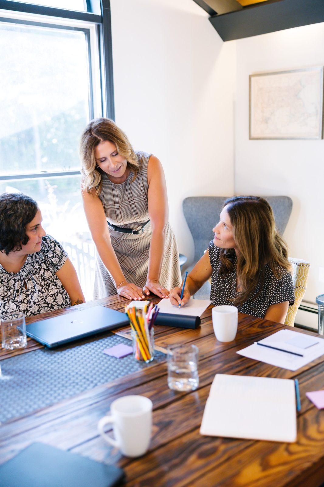 Laura Crosby supporting two participants as they work together at a table