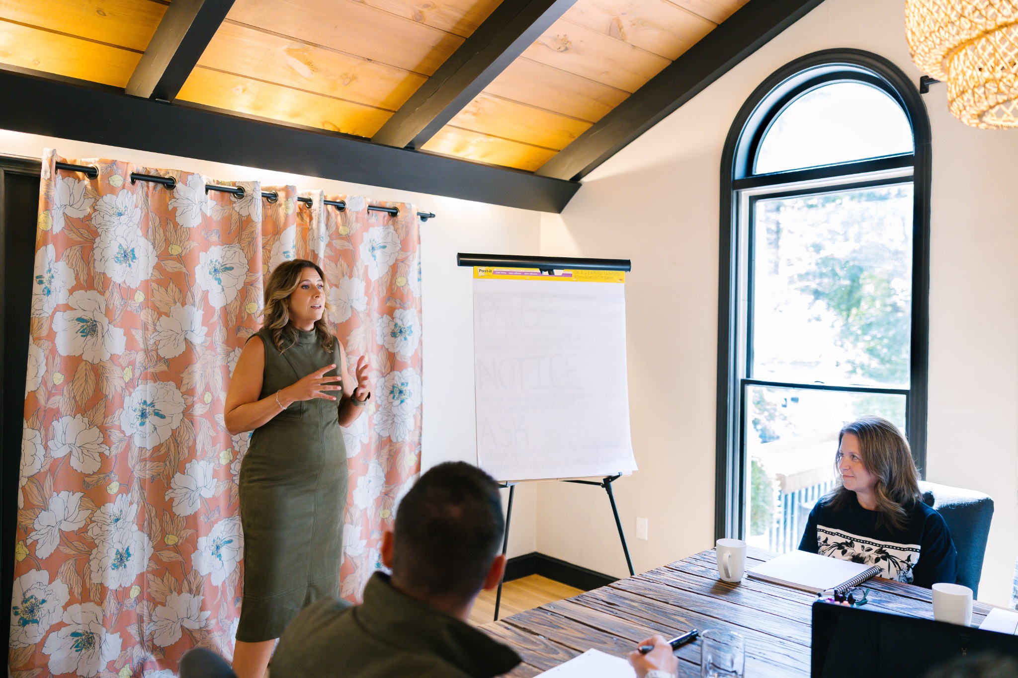 Laura Crosby facilitating a workshop with participants beside a flip chart